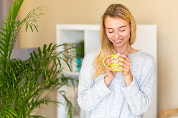 Frau mit einer Tasse mit goldener Milch mit Kurkuma